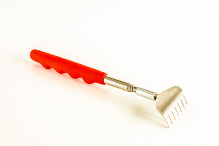 A red and silver tool with a handle. The tool is on a white backgroundの写真素材