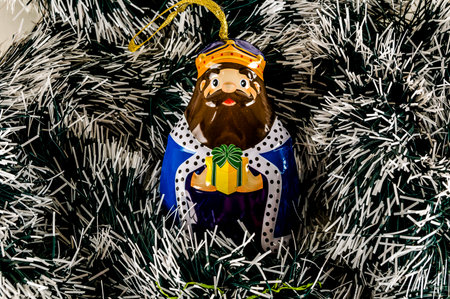 A small figurine of a man dressed in a crown holding a gift. The image has a festive and joyful mood, as it is likely a Christmas ornamentの写真素材