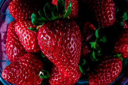 A close up of a bunch of red strawberries. The strawberries are fresh and ripe, with a bright red...