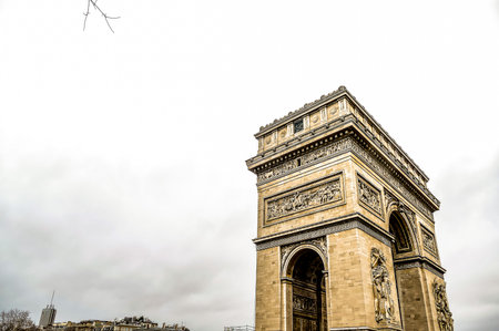 The structure is a large, ornate building with a large archway. The sky is cloudy and the sun is not visibleの写真素材