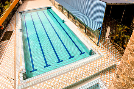 A pool with a blue tiled bottom and white tiles on the sides. The pool is emptyの写真素材