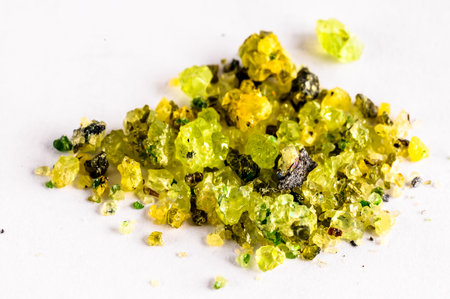 A pile of yellow and green rocks on a white surface. The rocks are of different sizes and shapes, and they appear to be made of quartz. Concept of natural beauty and tranquilityの写真素材