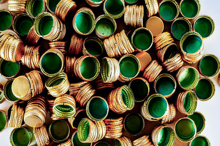 A pile of green and gold colored bottle caps. The caps are all different sizes and shapes. Concept of abundance and varietyの写真素材