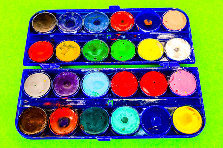 A blue box of paint with many different colors. The box is open and the paint is spread outの写真素材