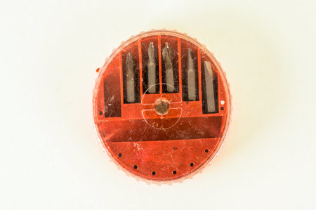 A red container with five different colored screwdrivers. The container is sitting on a white surface. Concept of organization and preparednessの写真素材