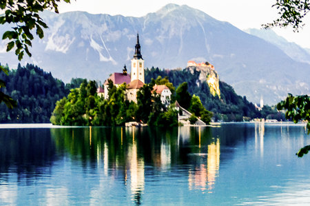 A beautiful lake with a castle in the background. The water is calm and the reflection of the castle is visibleの写真素材