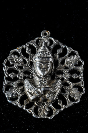Silver Buddha Pendant Jewel over a Black Backgroundの写真素材