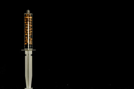 Medical Syringe Full of Pills on a Black Backgroundの写真素材