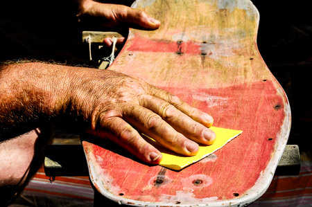 Restore an Old Skateboard with a Yellow Sandpaperの写真素材