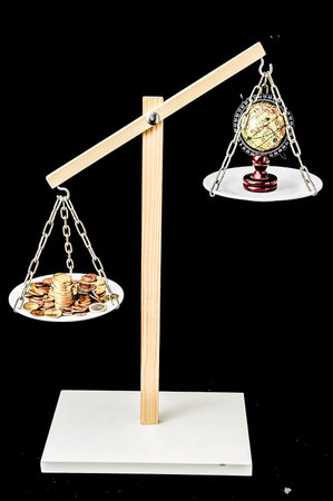 Globe Planet Earth and Money on a Two Pan Balanceの写真素材