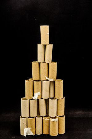 Empty Toilet Rolls Stack Up On a Black Backgroundの写真素材