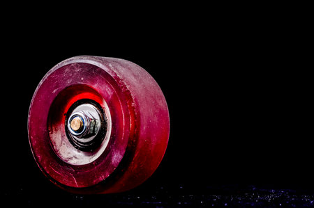Old Vintage Worn Skate Wheel on a Black Backgroundの写真素材