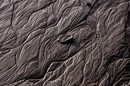 The image is of a rocky area with a lot of texture and detail. The rocks are jagged and rough, and the water is choppy. Scene is one of ruggedness and wildnessの写真素材