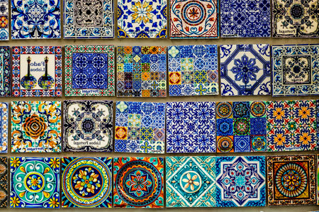 A wall of tiles with a variety of colors and patterns. The tiles are arranged in a way that creates a sense of depth and texture. Scene is one of creativity and artistic expressionの写真素材