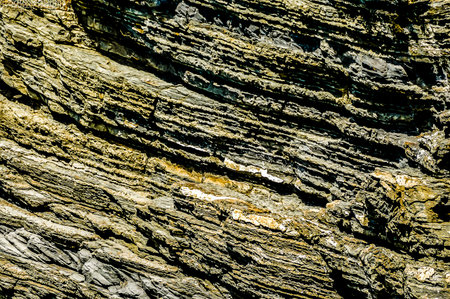 The image is of a rock with a lot of texture and a lot of detail. The rock is brown and has a lot of cracks and crevices. Scene is one of ruggedness and toughnessの写真素材