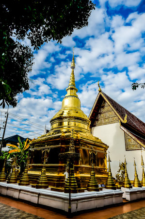 A gold and white building with a gold roof and a gold spire. The building is surrounded by a white wallの写真素材