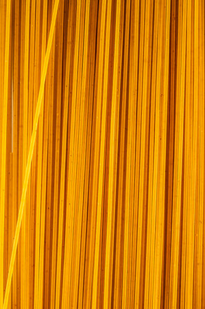 The image is of a long, thin strip of wood with a yellowish tint. The wood appears to be made of bamboo, and it has a striped pattern. The image has a warm, inviting moodの写真素材