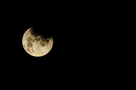 A large, bright moon is in the sky. The sky is dark and the moon is the only light sourceの写真素材