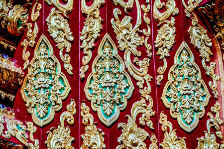 A red and gold design with intricate patterns and flowers. The gold and red colors create a sense of luxury and opulence, while the intricate details of the design suggest a sense of craftsmanshipの写真素材