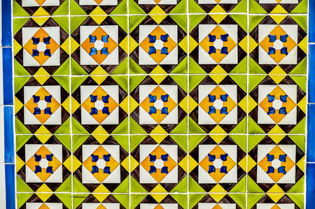 A tile pattern with yellow, green, and blue tiles. The tiles are arranged in a way that creates a sense of movement and energyの写真素材