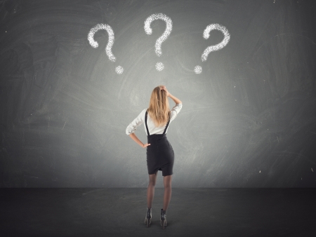 Confused businesswoman  thinking, looking at questions mark in the wallの写真素材