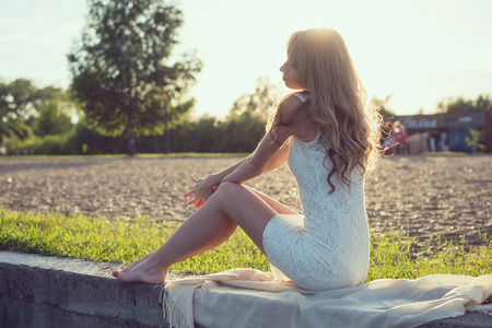 Sunny outdoors portrait of a beautiful young romantic woman or girl under sunset  Summer evening nature  Soft light  Toned warm colors の写真素材