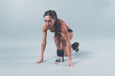 Sportive athlete woman sprinter waiting for the start running position fitness, sport, training and...