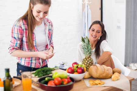 Women preparing dinner in a kitchen concept dieting healthy food cooking at homeの写真素材