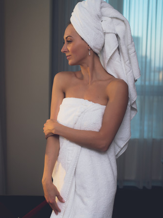 Naked woman with towel on her head and body after bathの写真素材