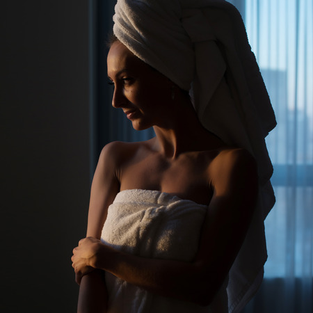 Naked woman with towel on her head and body after bathの写真素材