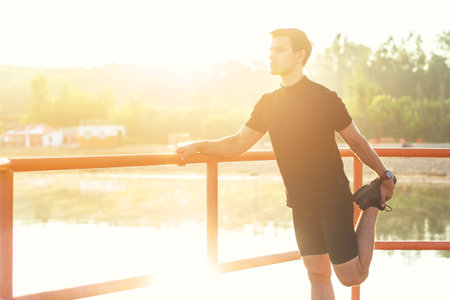 Fitness man stretching his leg before a run outdoors.