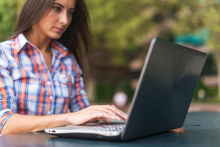 Close up shot of female hands typing on a laptop keyboardの写真素材