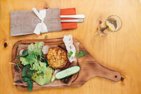 Top view of healthy meal. Fresh salad with grilled vegetable ball served on wooden cutting boardの写真素材