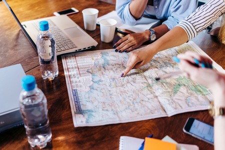 Planning vacation. Close up view of female hands pointing at places on map.の写真素材