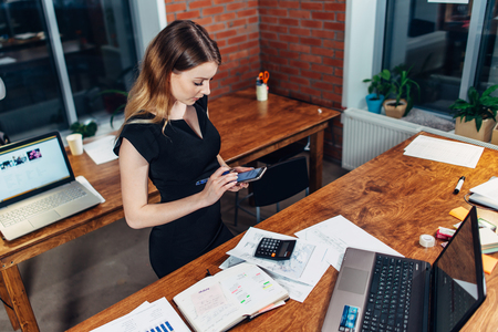 Top view of woman working using smartphone standing at her workplace in creative officeの写真素材
