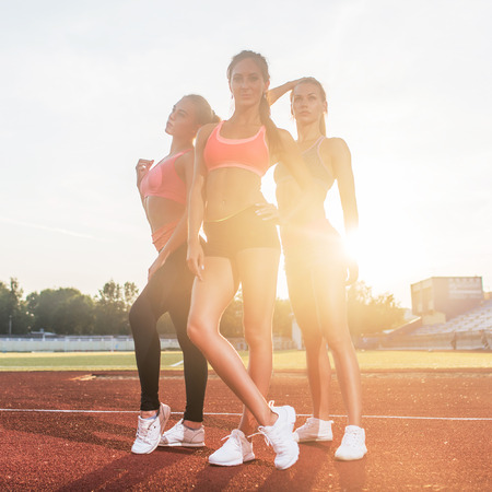 Group of fit young sportswomen standing in athletics stadium and posing.の写真素材