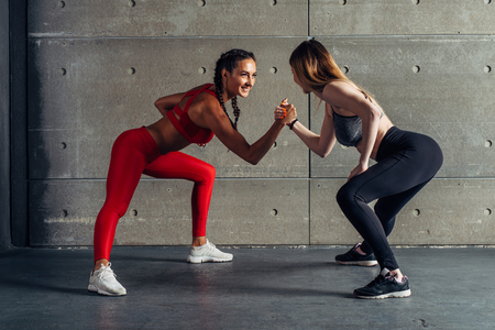 Fit woman wrestle on hands with a female opponent looking in her eyes.の写真素材