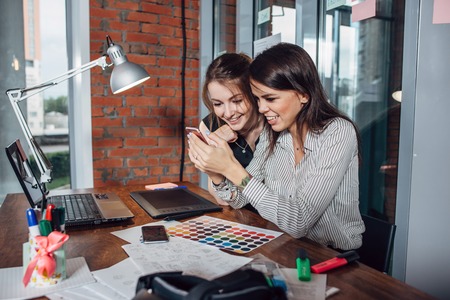 Two creative female designers choosing colors working with colour palette in the officeの写真素材