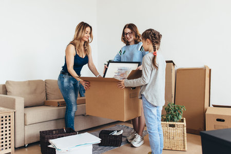 Family unpacking cardboard boxes at new home