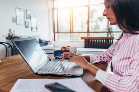 Young woman working at home using laptop computerの写真素材