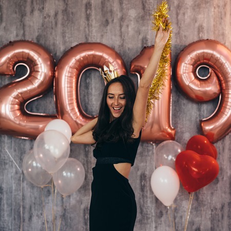 Young woman with balloons posing celebrating New Yearの写真素材