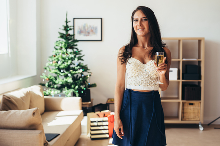 Celebration Christmas, New Year. Young woman holding a champagne flute.の写真素材