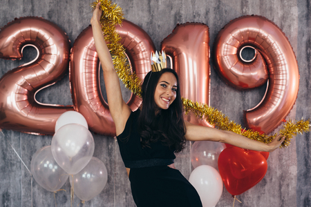 Young woman with balloons posing celebrating New Yearの写真素材