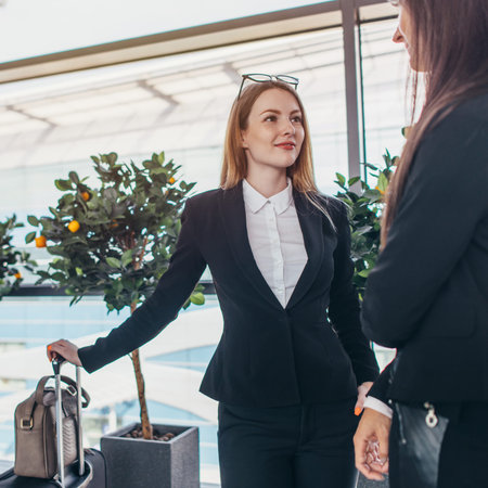 Two smiling business partners talking standing in airport
