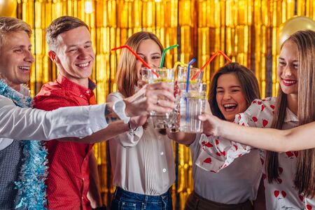 Group of friends toasting, cheering with cocktailsの写真素材