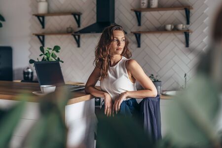Young female entrepreneur sits at kitchen tableの写真素材