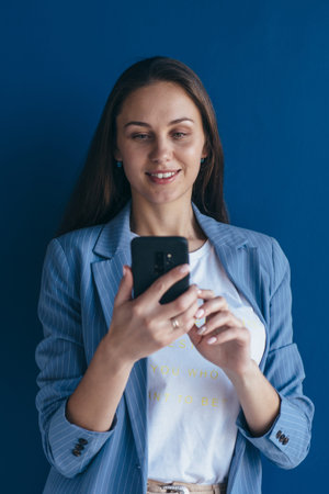 Young businessman looking at smartphone, using mobile app.