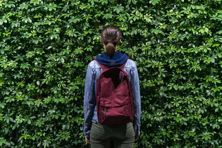 Photo of a woman view from behind on a green leaf backgroundの写真素材