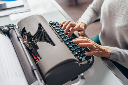 Female fingers on the keys of the typewriter type text.