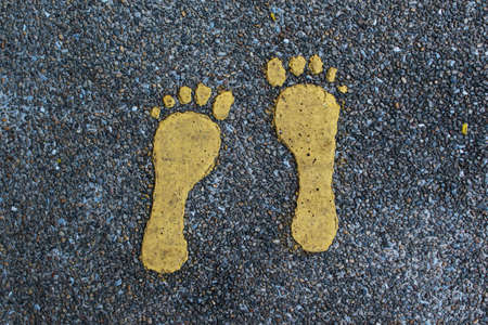 Pedestrian walkway. Footprints painted on asphalt.の写真素材